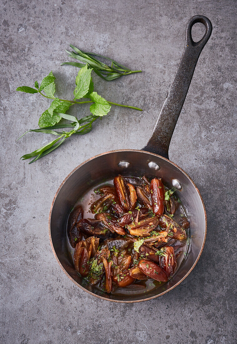 Orange dates with mint and tarragon in a pot