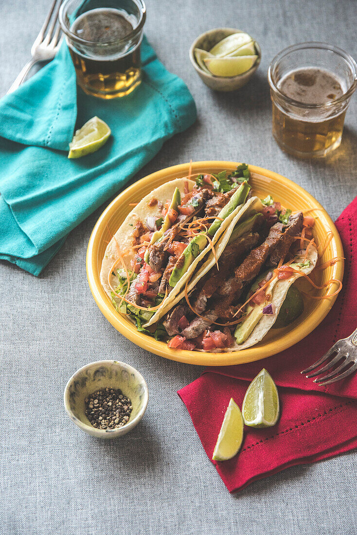 Taco with steak, salsa, lime, and avocado