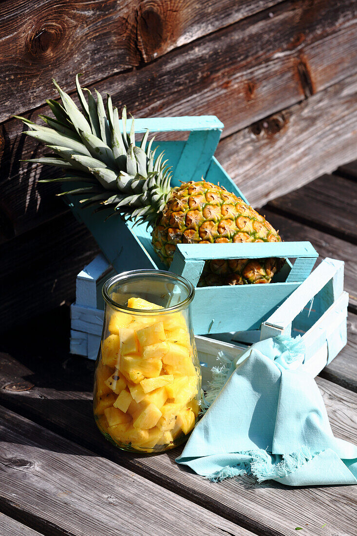 Ananaswürfel im Glas und ganze Ananas im Holzkästchen (zum Fasten)