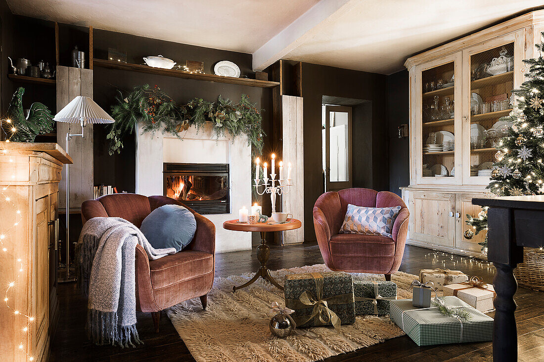 50s armchair with velvet upholstery in front of fireplace in living room decorated for Christmas