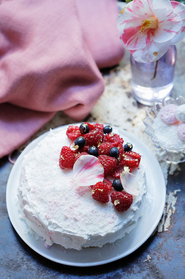 Romantic Spring iced white cake with raspberries and blueberries