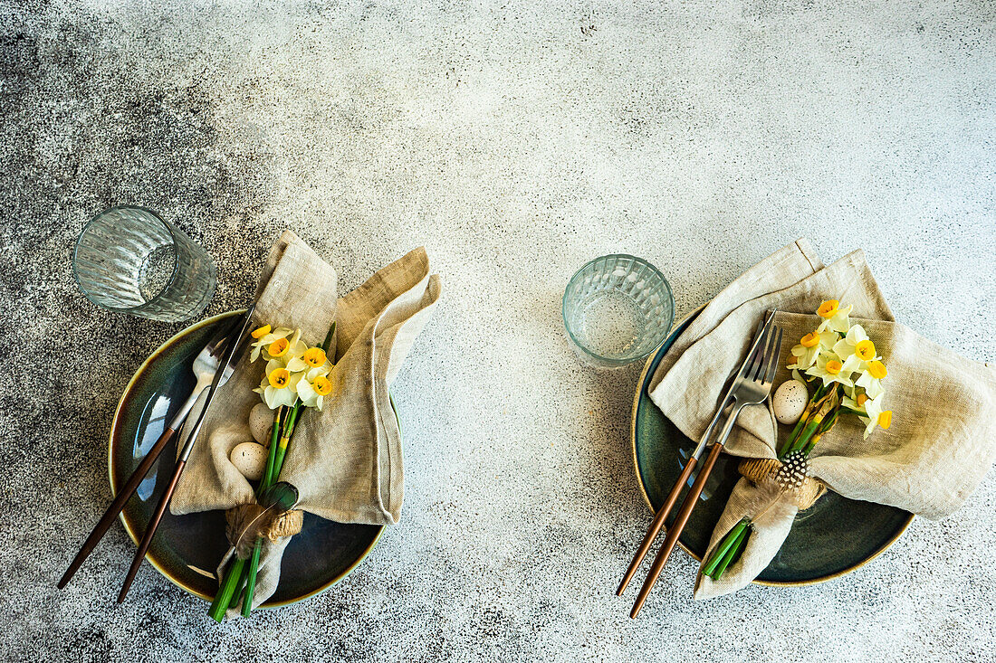 Minimalistic table setting for easter festive dinner decorated with daffodil flowers