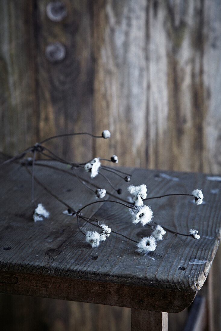 Branch with white blossoms on a rustic wooden table
