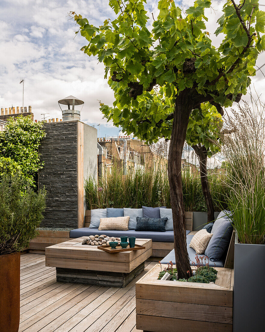 Gartengestaltung mit maßgefertigten Holzmöbeln auf der Dachterrasse