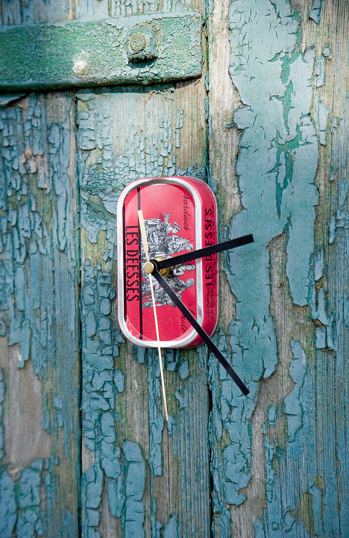 Upcycling, alte Fischdose, Uhr, die an der blauen alten Holzwand hängt