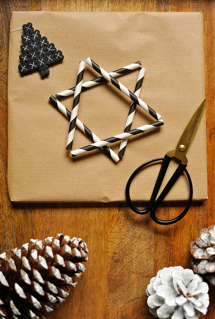 Geschenkpapier verziert mit Stern aus gestreiften Trinkhalmen