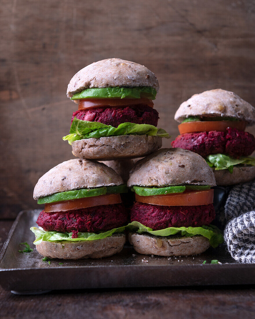 Vegan mini burgers with beetroot patty, lettuce, tomato and avocado