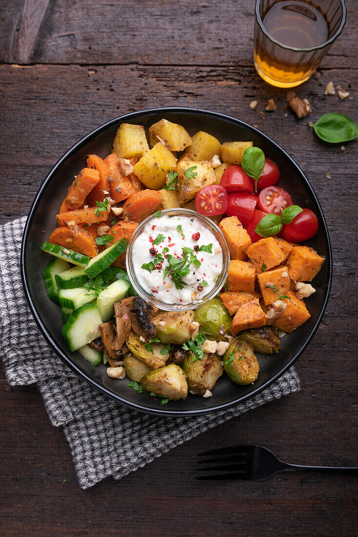 Vegan bowl with sweet potatoes, potatoes, vegetables and herb dip