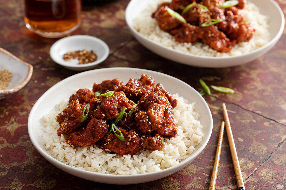 Korean crispy twice fried chicken with hot sauce and sesame seeds