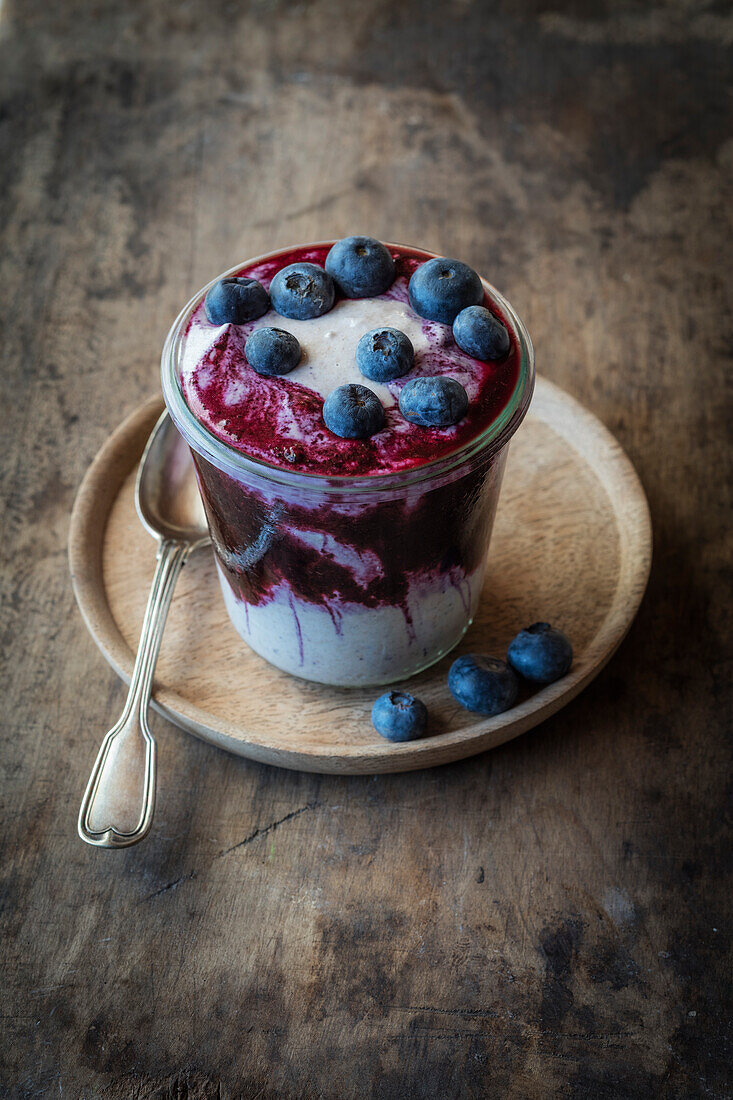 Blueberry buckwheat porridge cup topped with blueberry on table