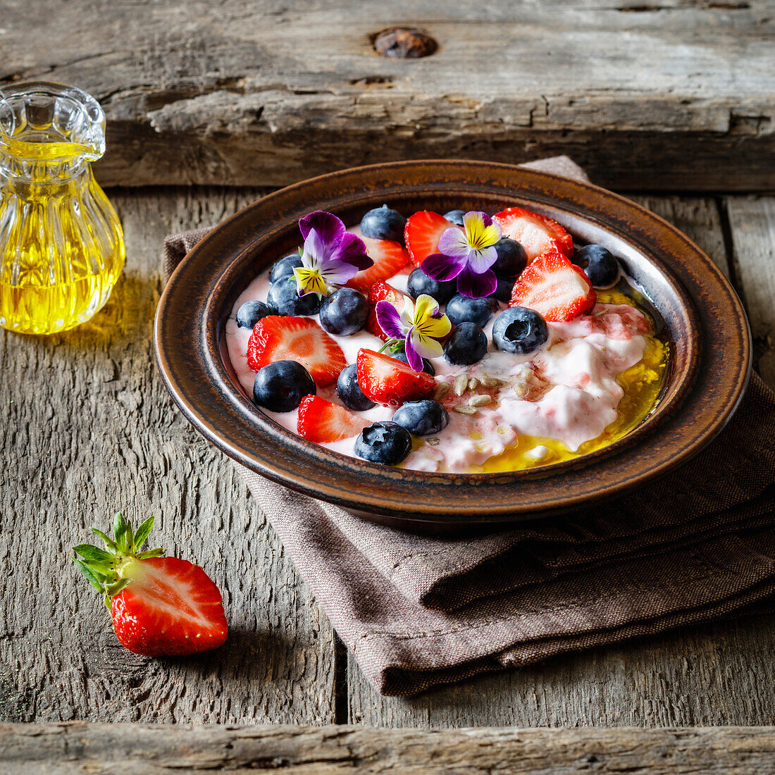 Plate of quark with strawberries, blueberries and edible flowers