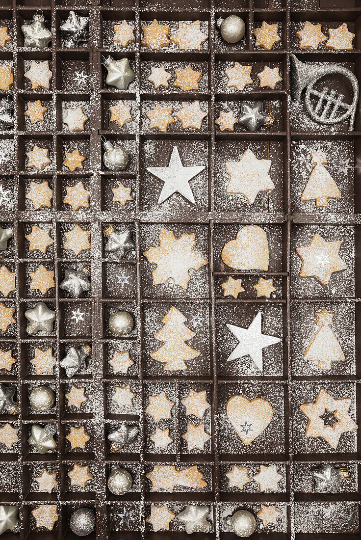 Hausgemachte Weihnachtsplätzchen, Sterne und Weihnachtskugeln in alten Holzkoffern