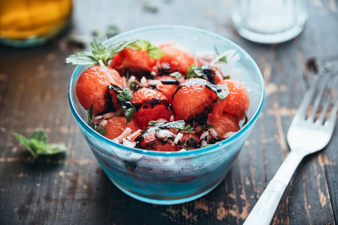 Wassermelonensalat mit Eschalot, Minze, Olivenöl und Balsamico in einer Schüssel