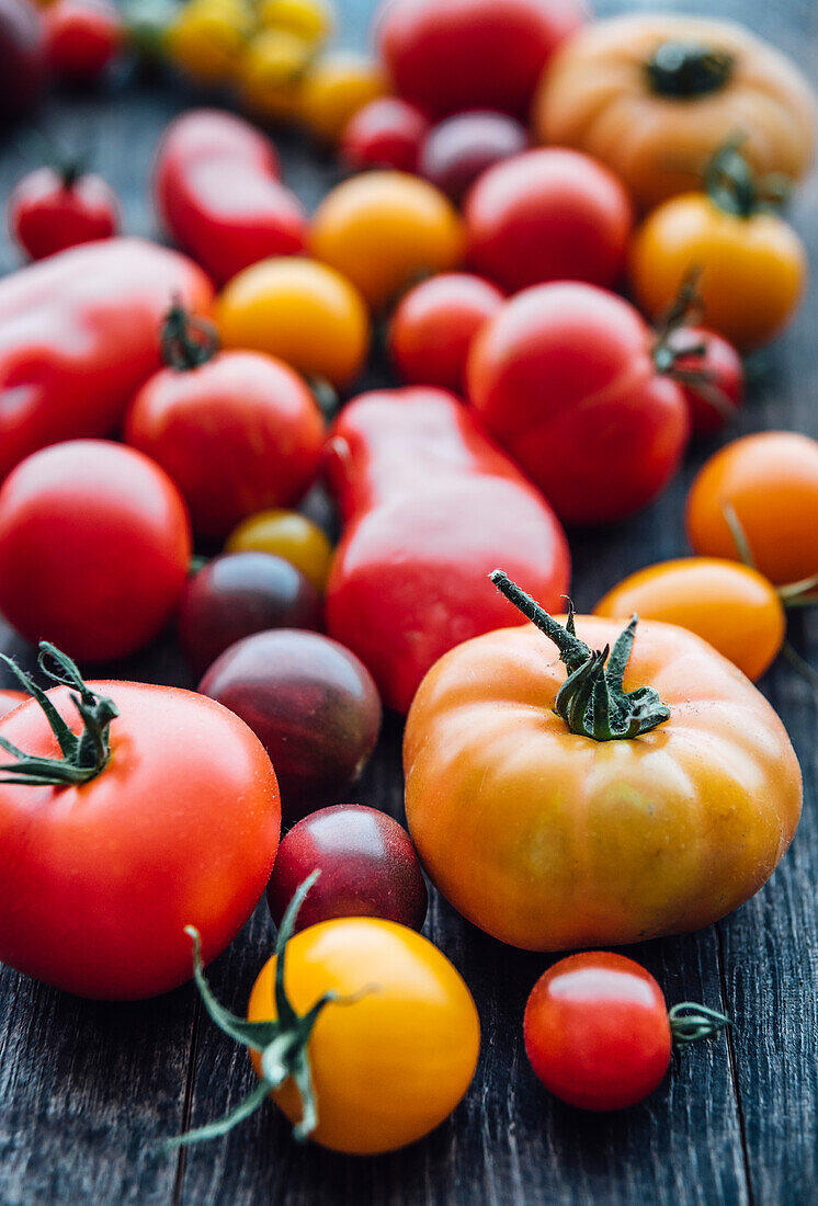 Different sorts of tomatos on woodden background