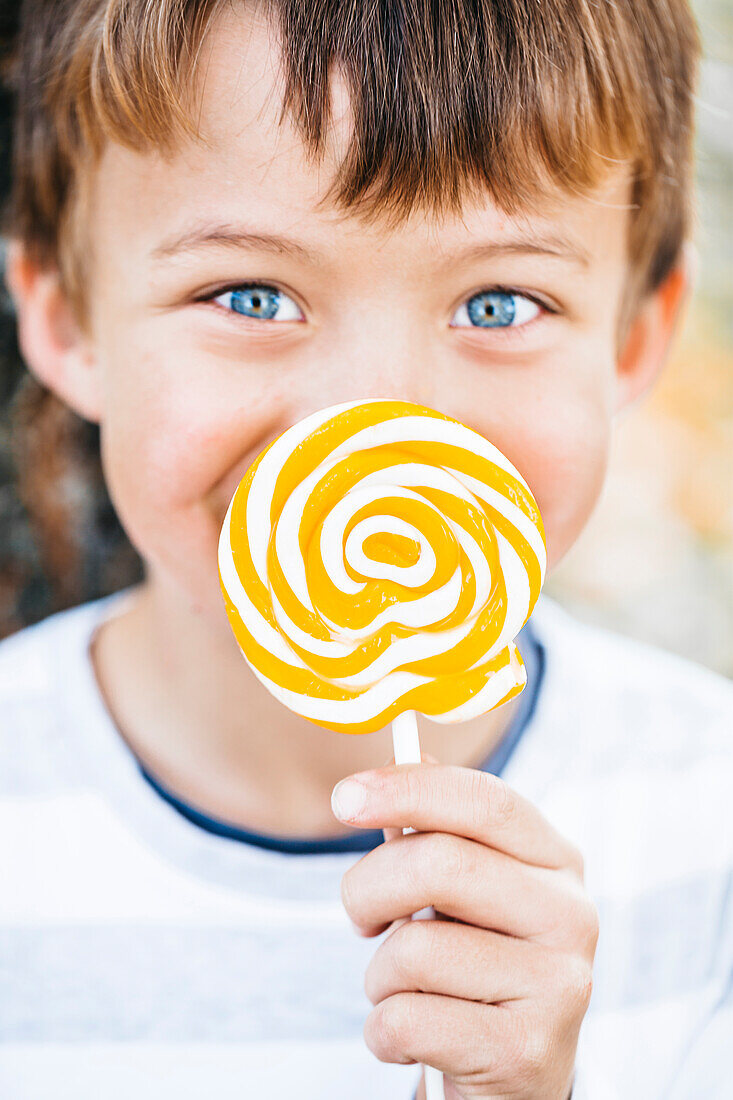 Portrait of little boy with lollipop