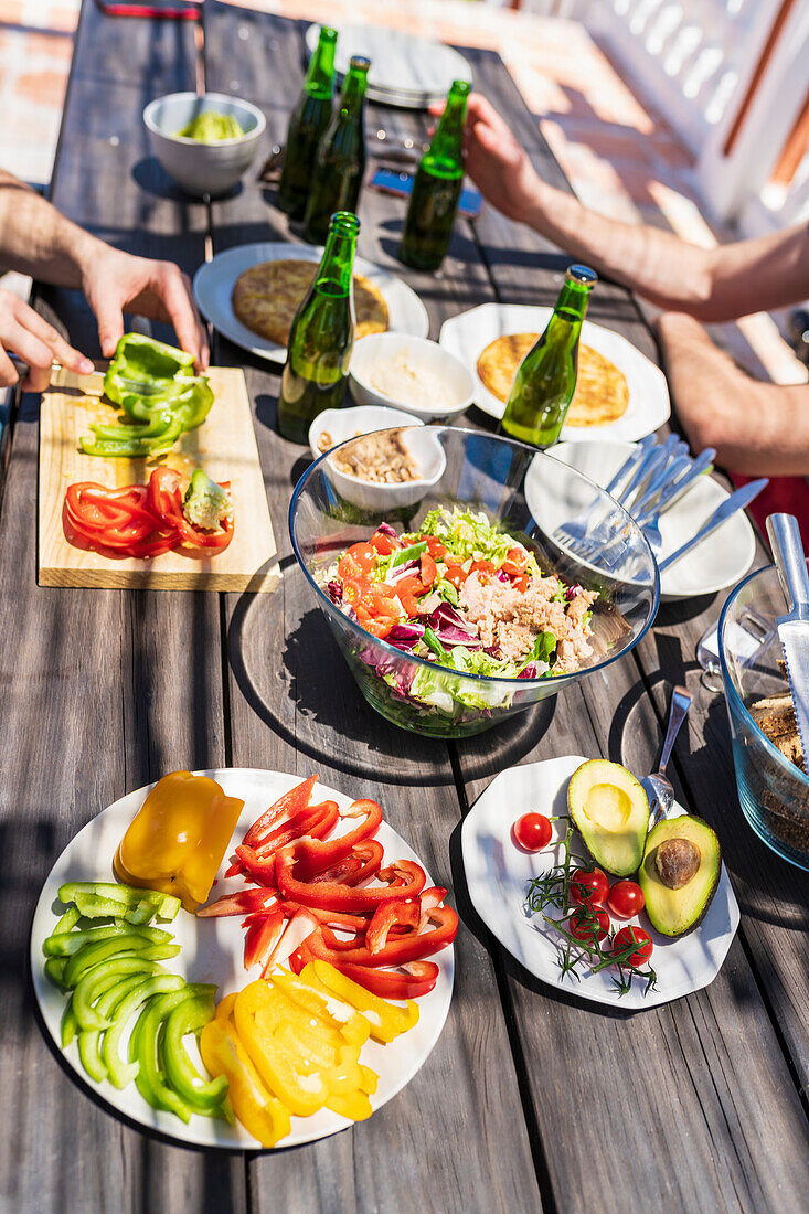 Brunch am Tisch mit männlichen Freunden an sonnigen Tagen auf der Terrasse