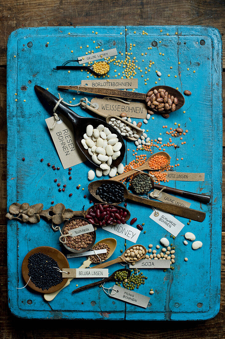 Various beans and lentils on blue?rustic wooden surface