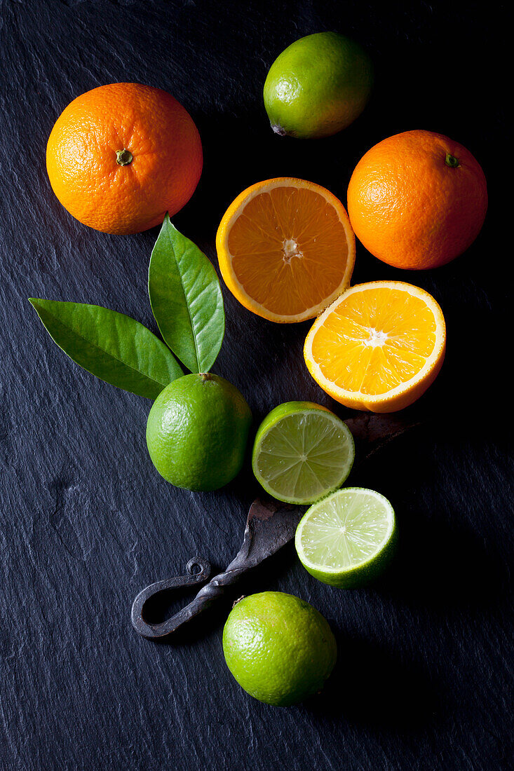Geschnittene Limetten und Orangen mit einem alten Messer