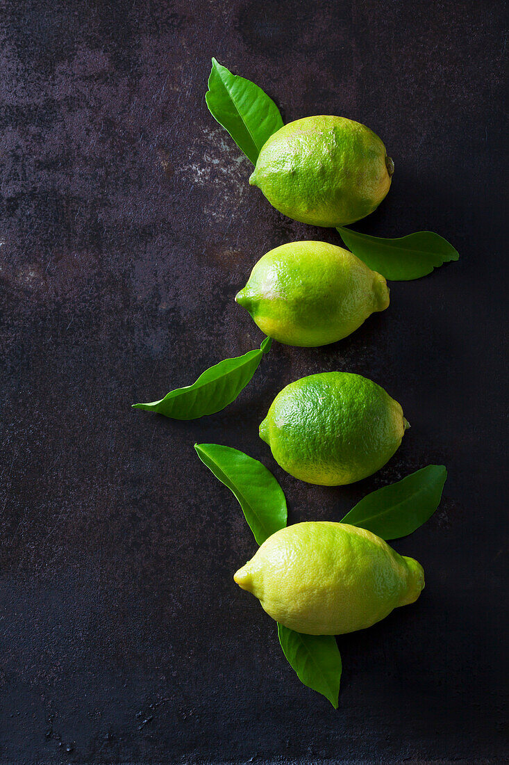 Grüne Bio-Zitronen auf dunklem Hintergrund