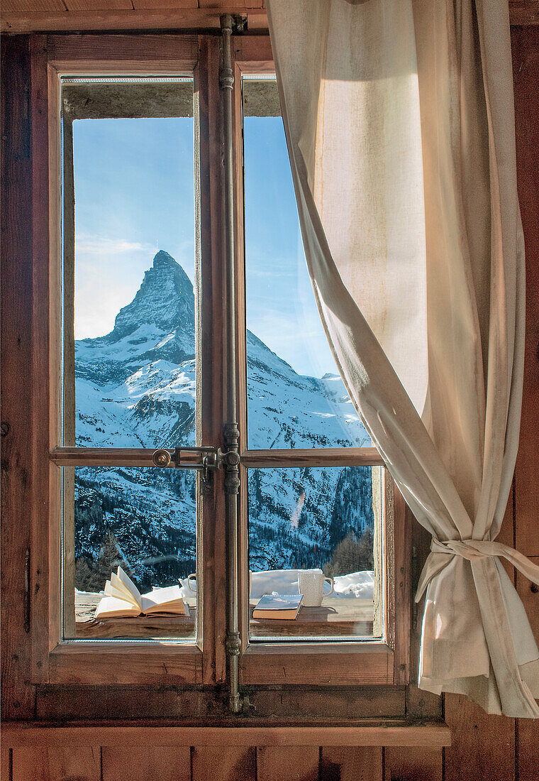 View of the Matterhorn peak through a window with a rustic wooden frame