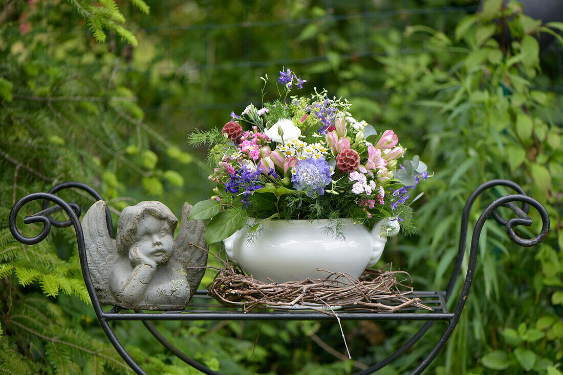 Colourful wildflower bouquet in tureen in garden