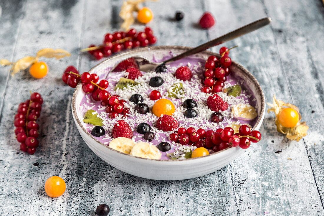 Yogurt with fruits, blueberry, red currants, raspberry, kiwi, banane, physalis