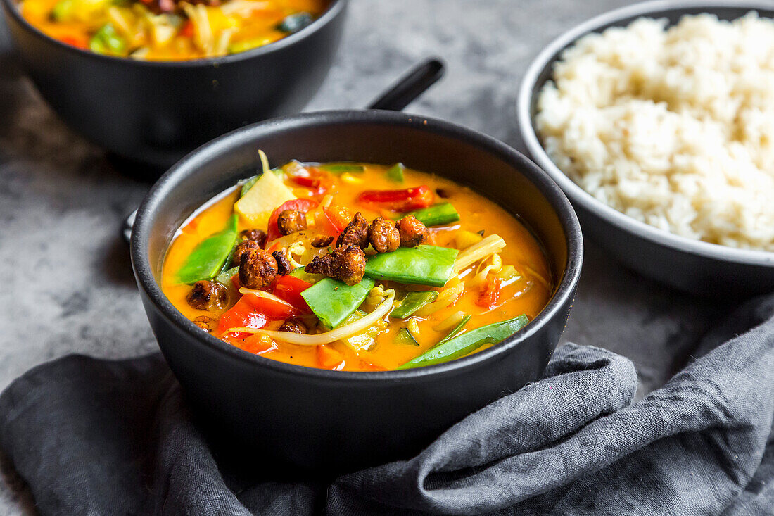 Red curry in bowls, rice