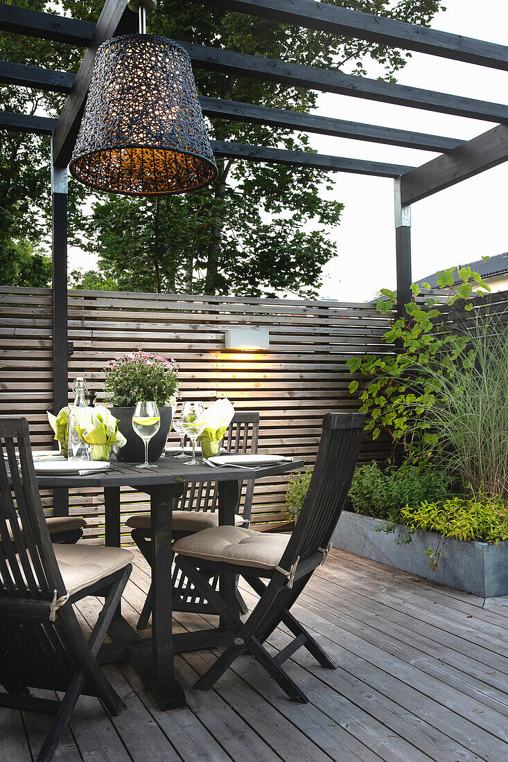 Table with drinks and chairs on a wooden terrace