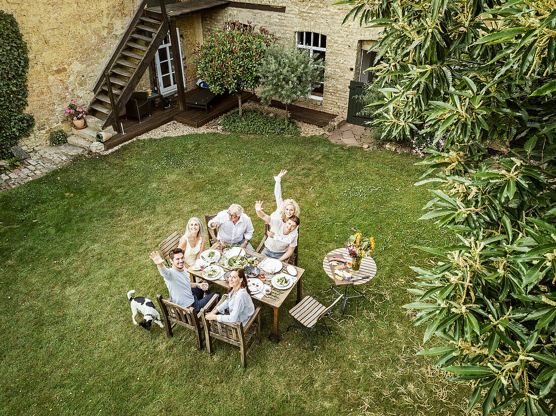 Family eating together in the garden in summer