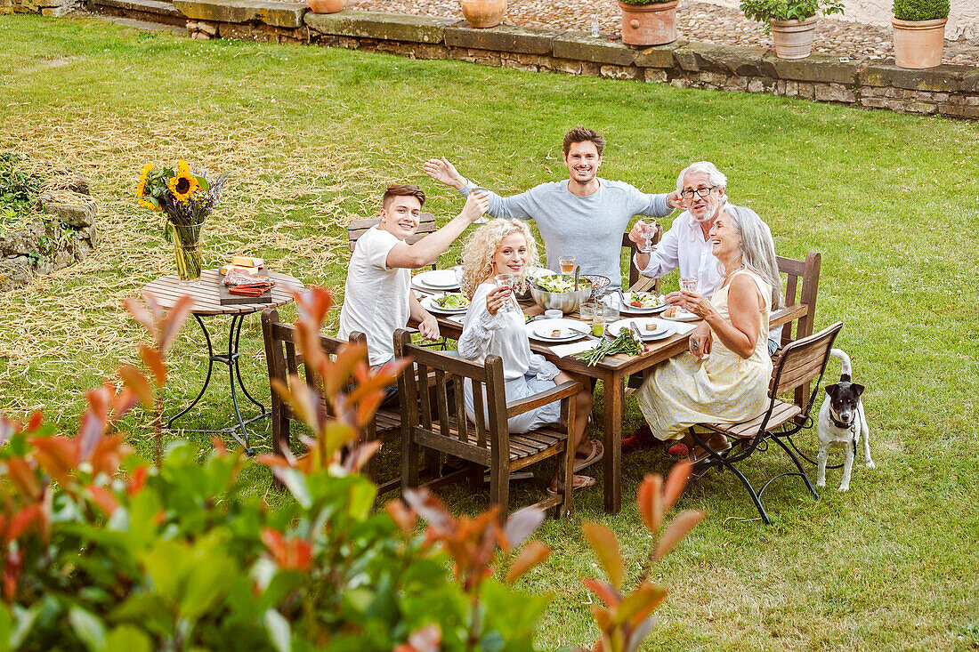 Family eating together in the garden in summer