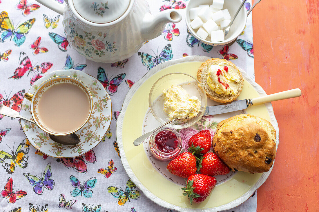Afternoon tea with scones, clotted cream, strawberries, jam and tea with milk