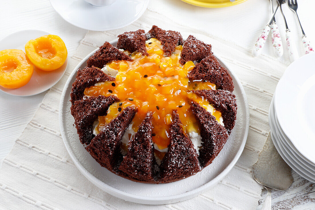 Chocolate sponge cake stuffed with cheese mass and decorated with mango and passion fruit mousse
