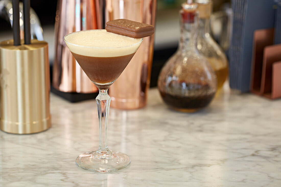 An espresso martini garnished with a chocolate biscuit