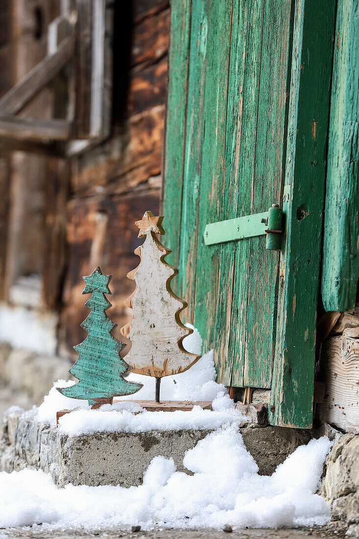 Wooden fir trees on snowy stone steps