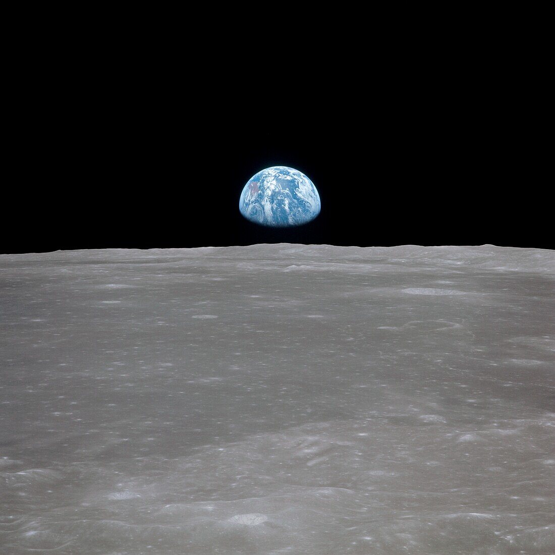Apollo 11 view of the Earth rising over the Moon's horizon