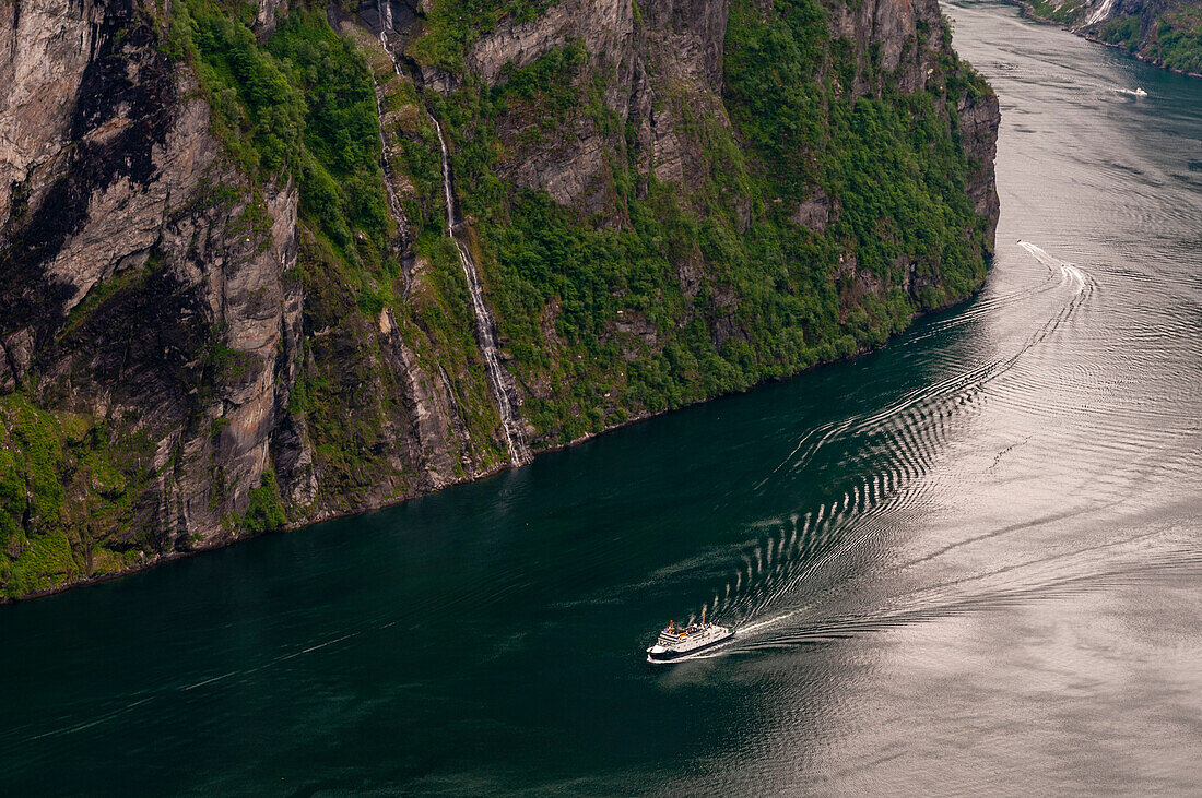 Cruise ship navigating past cliffs in Geirangerfjord, Norway