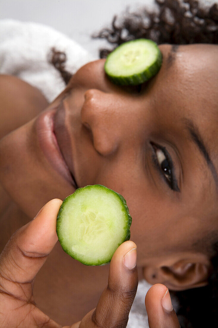 Woman with cucumber over eyes