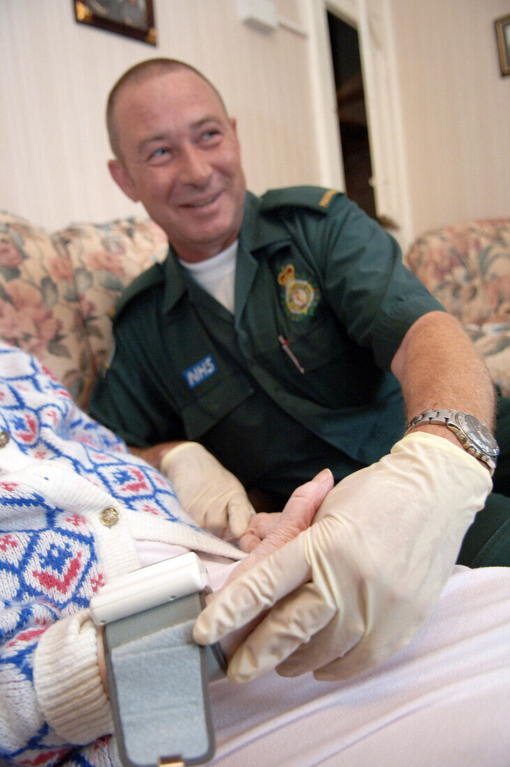 Paramedic holding elderly patients hand