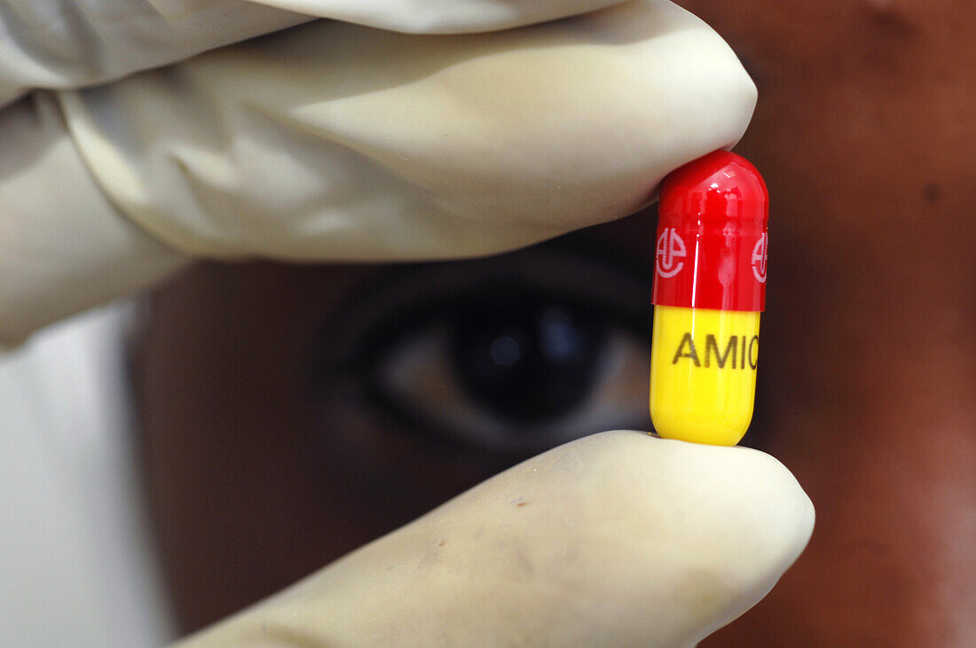 Pharmaceutical worker holding a freshly made drugs capsule
