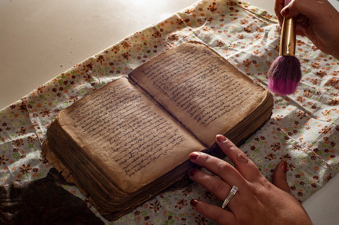 Restorer working on a deteriorated old book, Armenia
