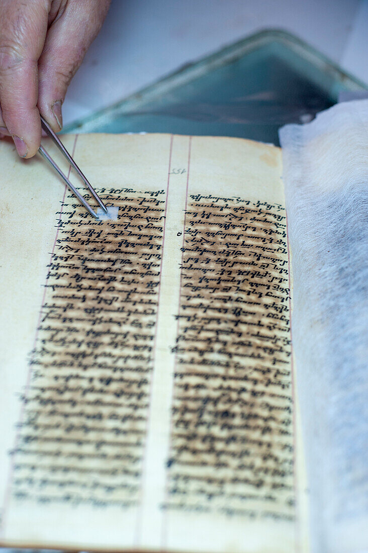 Restorer restoring an old manuscript
