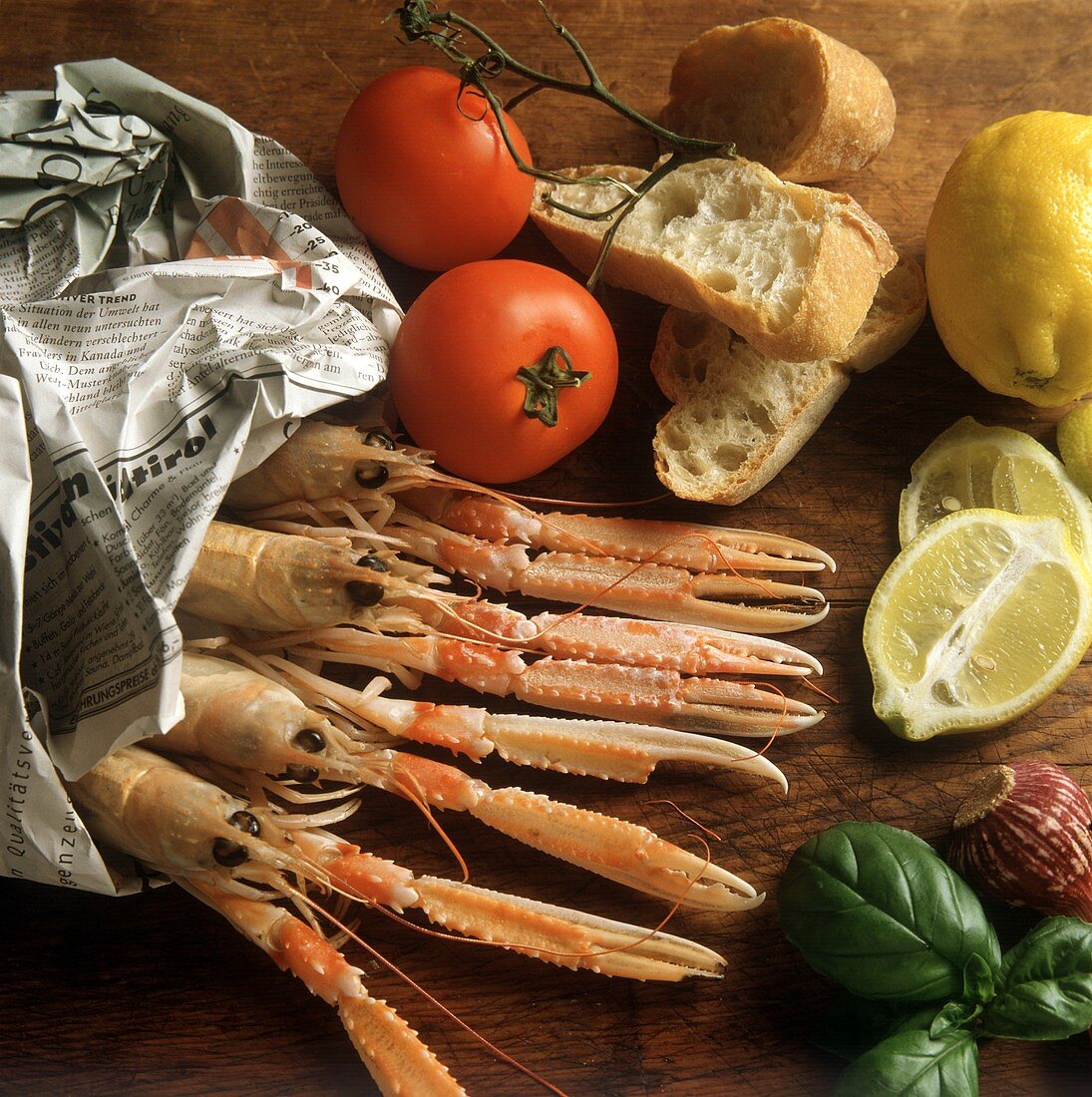 A few fresh scampi in newspaper & vegetables, bread