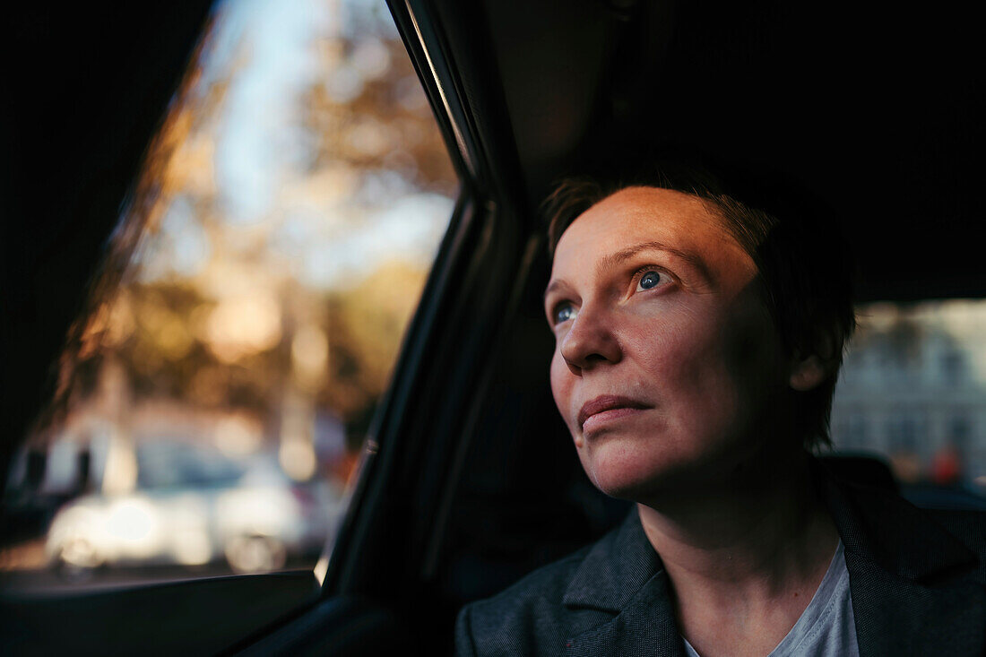 Hopeful businesswoman looking out of a car window