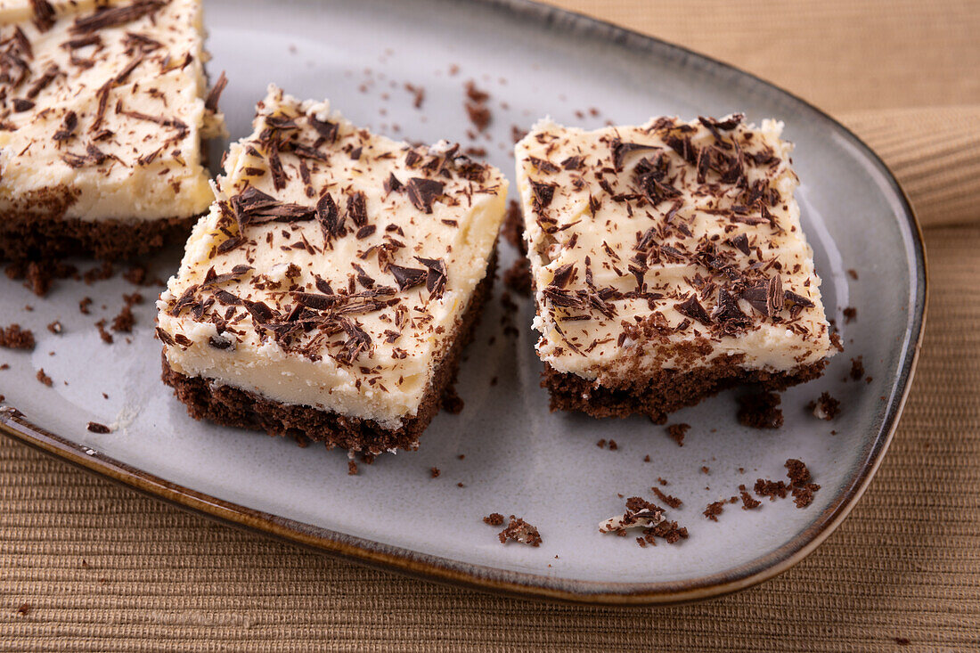 Vegan walnut-chocolate cake on a tray with vanilla cream