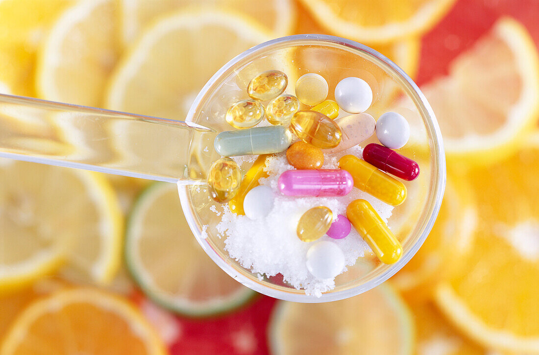 Verschiedenene Vitamintabletten und Nahrungsergänzungsmitteln auf Zitrusscheiben