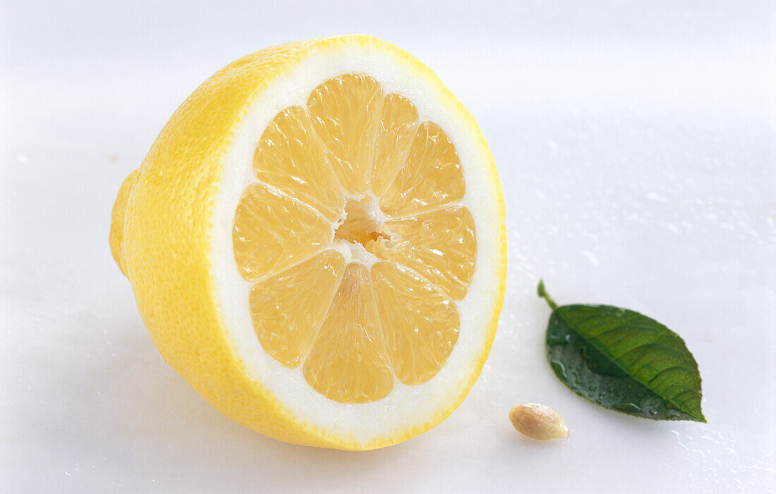 Halbierte Zitrone mit Blatt und Zitronenkern