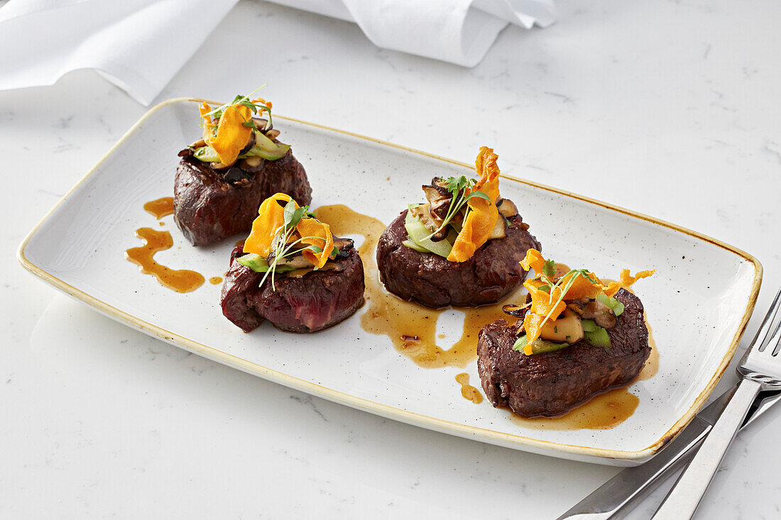 Medallions of beef with crispy parsnip, mushrooms and spring onion