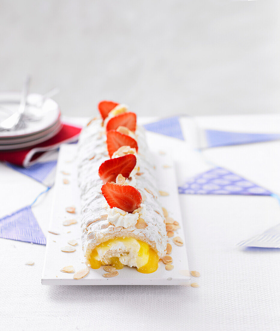 Lemon meringue roulade with almonds and strawberries