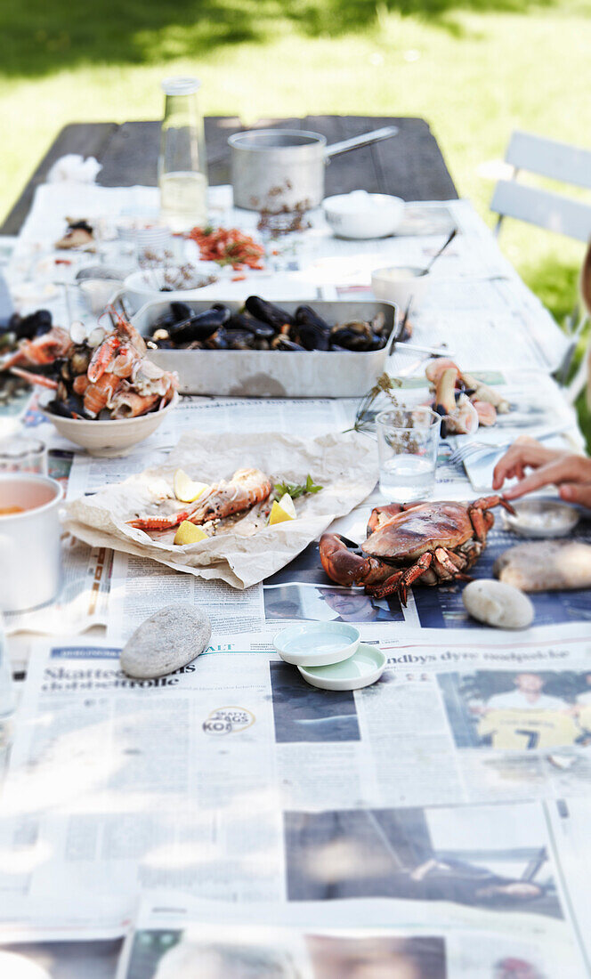 Meeresfrüchtegerichte auf sommerlichem Tisch im Freien