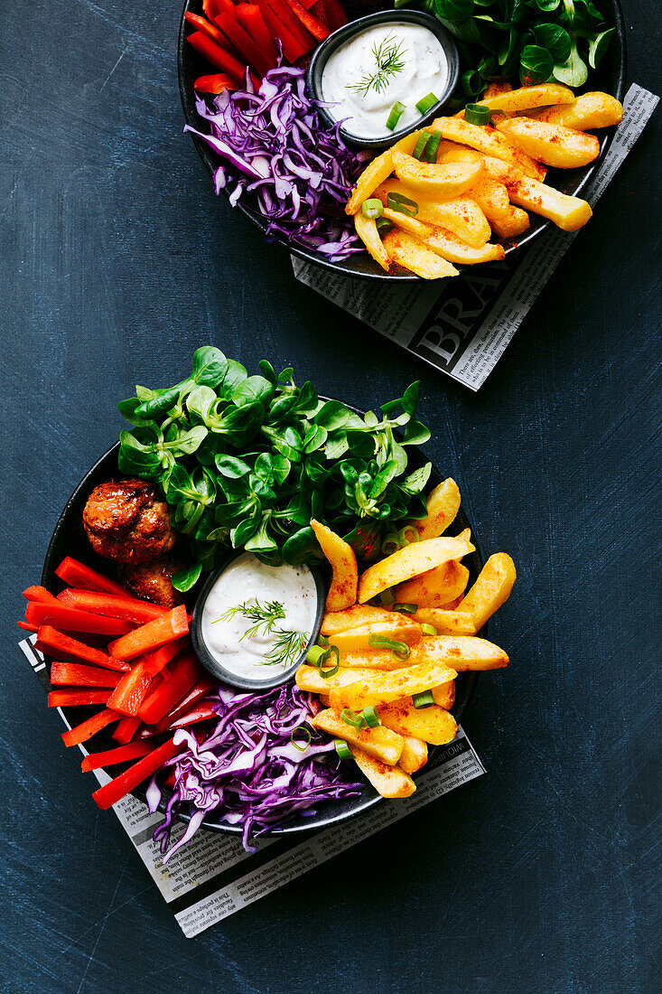 Bunte Veggie Bowl mit Kartoffelspalten und veganen 'Hackbällchen'